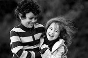 Brother and sister enjoy playing in the park, black and white image