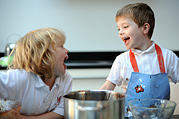 Two friends share a laugh while baking in the kitchen