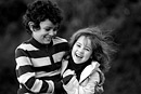 A brother and sister play together in the park, black and white image