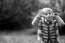 A boy pulls a face and pokes out his tongue, black and white image