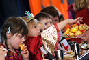 Children dressed for a school nativity play eat their lunch