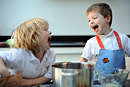 Two boys share a laugh while baking in the kitchen