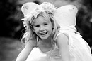 A girl plays dressed as an angel, black and white image