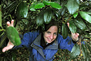 A woman emerges from beneath a tree