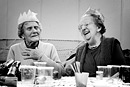 Two elderly ladies at a party share a laugh
