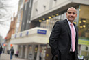 A man poses outside a busy retail outlet