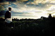 A model poses in a field of sunflowers during a fashion shoot