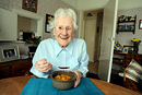 Portrait of an elderly woman enjoying her lunch provided by meals on wheels