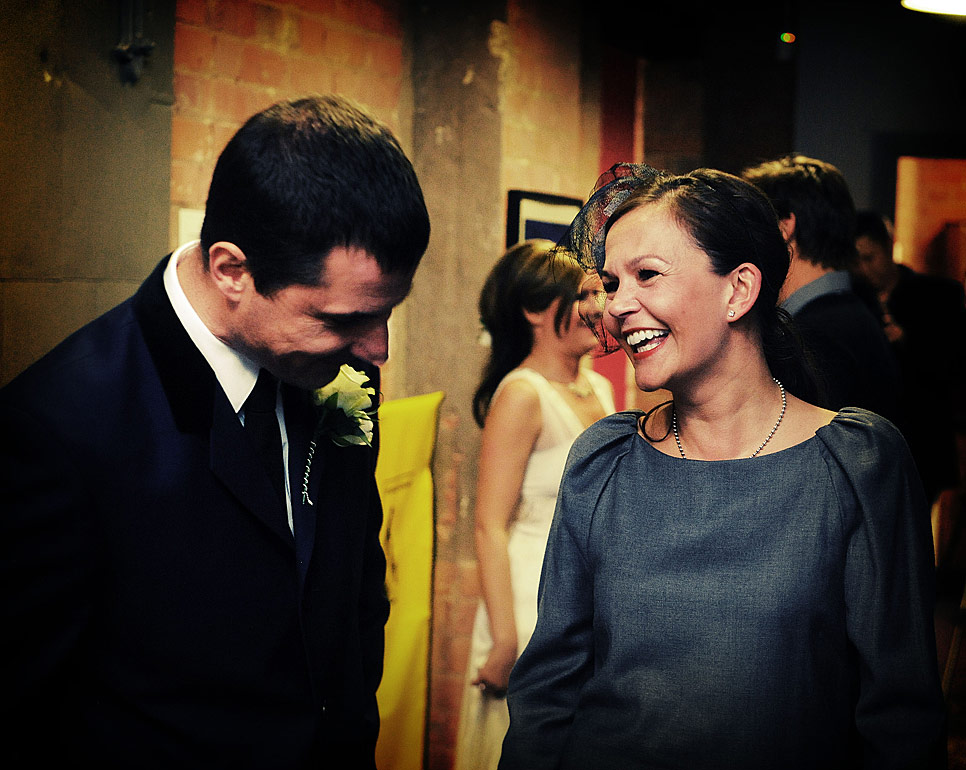 The groom shares a joke with a guest